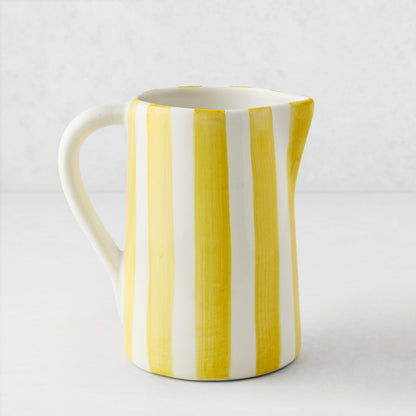 Medium Portofino ceramic pitcher with hand-painted yellow and white vertical stripes, curved handle and spout.