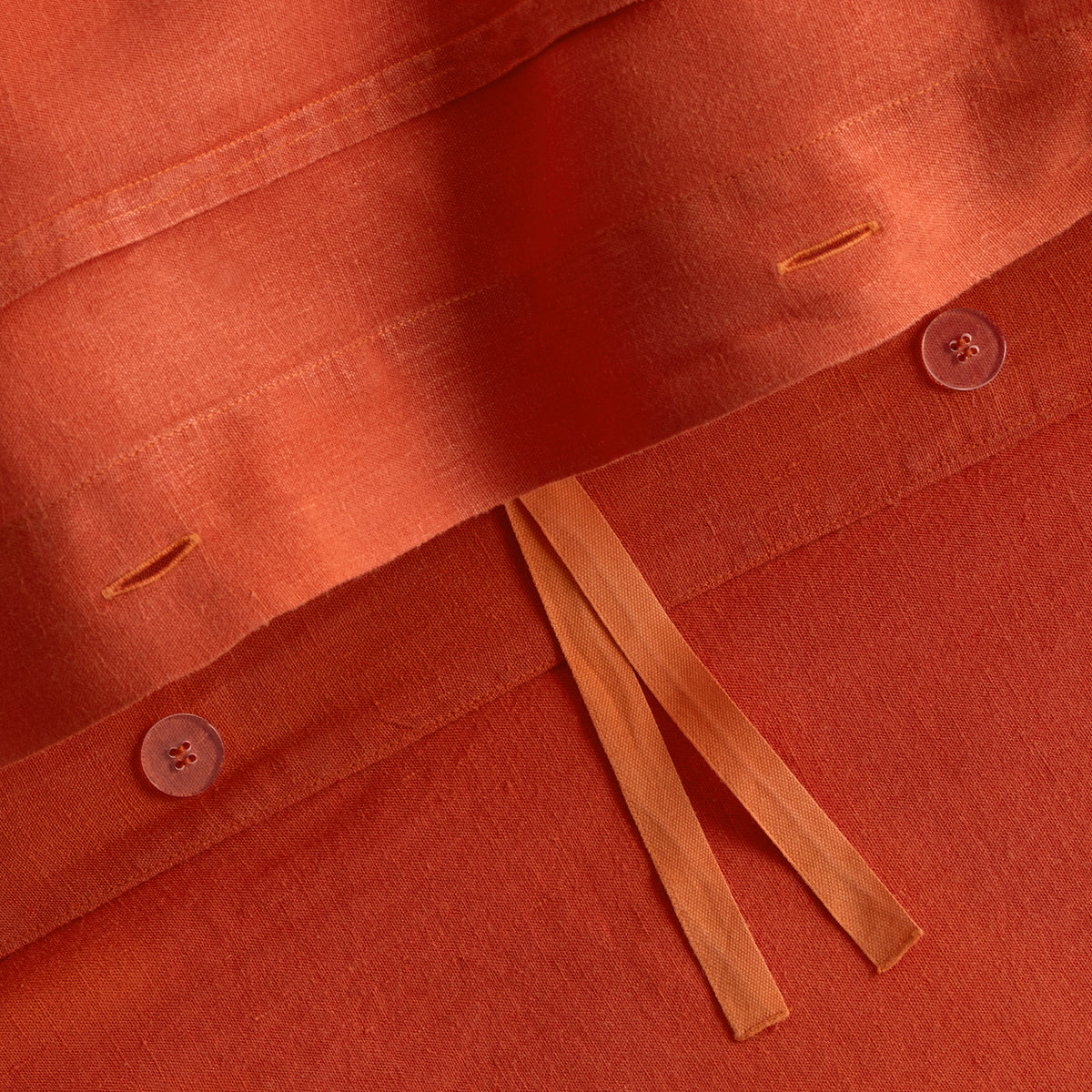 Pumpkin orange European washed linen duvet cover with button closures and fabric ties.