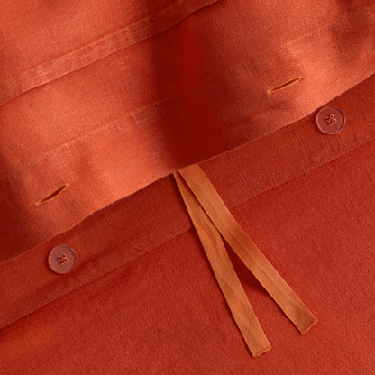 Pumpkin orange European washed linen duvet cover with button closures and fabric ties.
