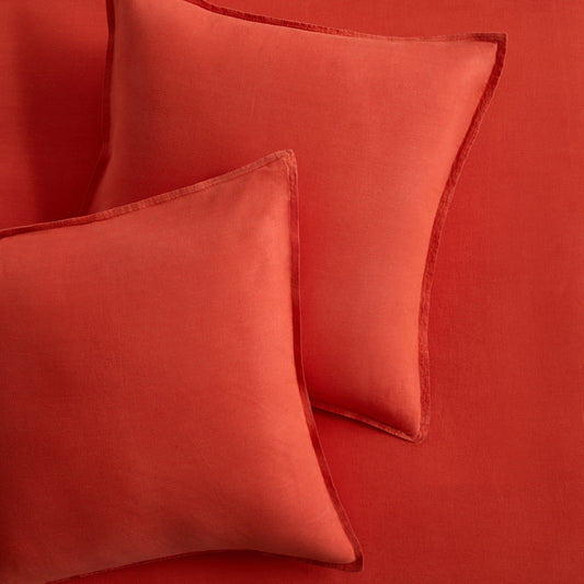 Set of two pumpkin orange European washed linen euro shams with a soft, textured finish.