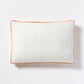 White linen lumbar pillow with pumpkin orange velvet gusset, 20x14 inches.