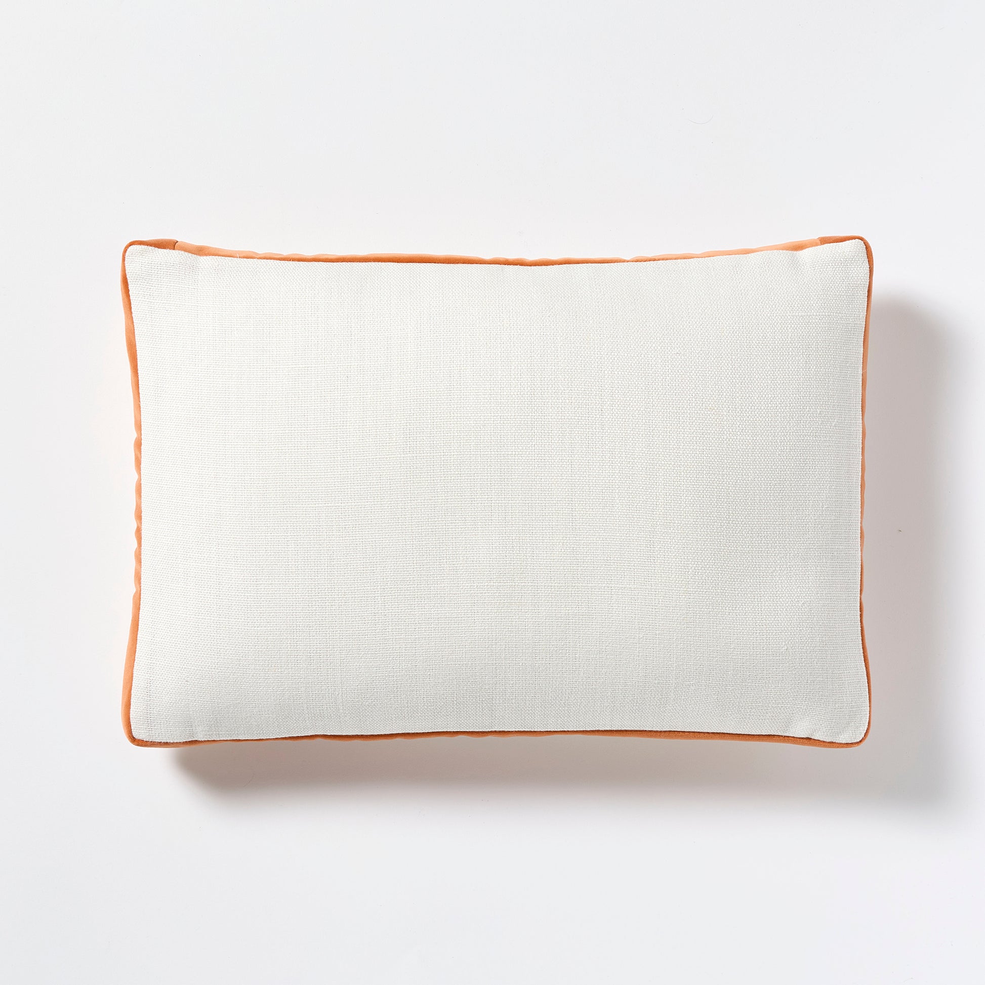 White linen lumbar pillow with pumpkin orange velvet gusset, 20x14 inches.