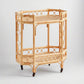 Natural Raelyn Bar Cart with two dark wood shelves, handmade rattan frame, and rolling casters.