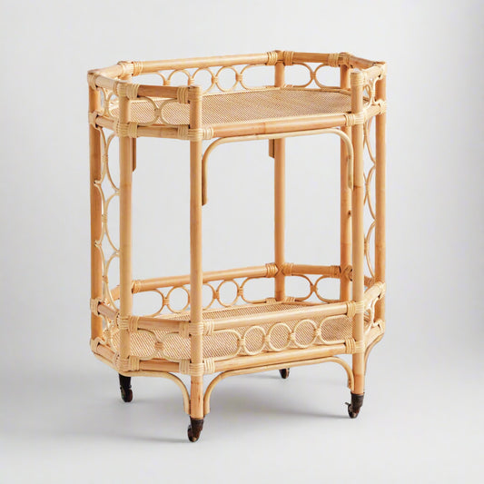 Natural Raelyn Bar Cart with two dark wood shelves, handmade rattan frame, and rolling casters.