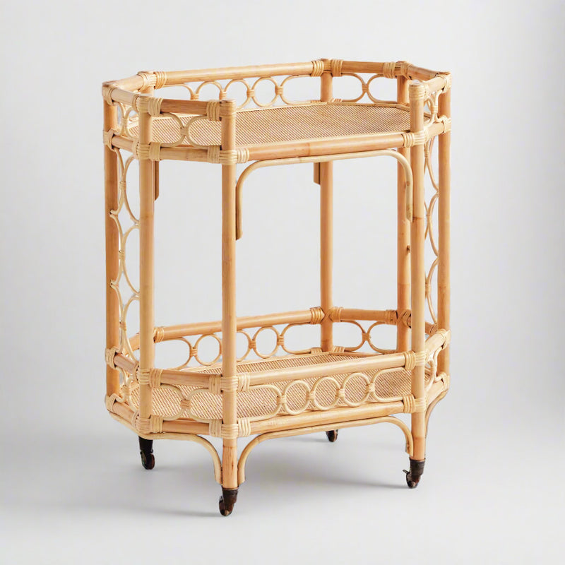 Natural Raelyn Bar Cart with two dark wood shelves, handmade rattan frame, and rolling casters.