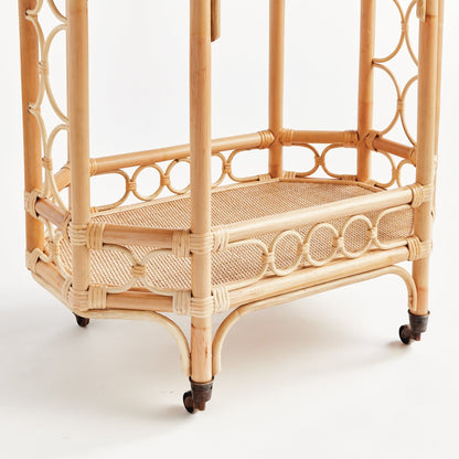 Natural rattan bar cart with woven shelves and dark wood accents on casters.