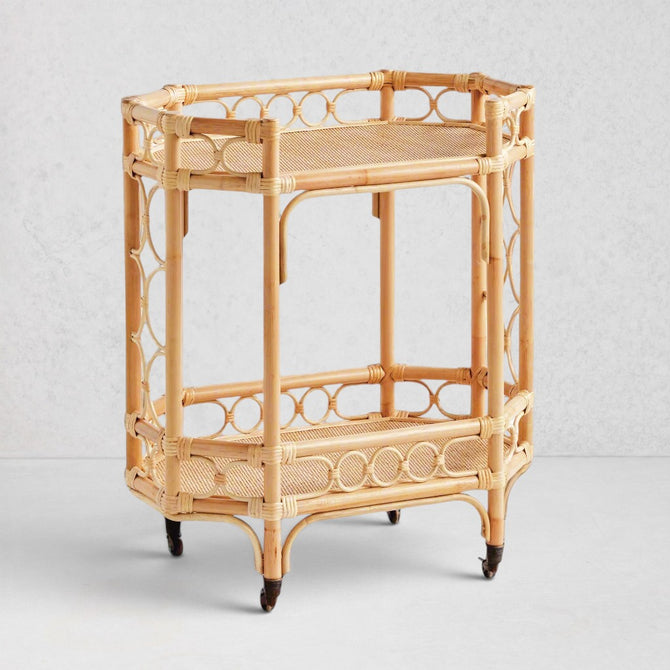 Natural Raelyn Bar Cart with two dark wood shelves, handmade rattan frame, and rolling casters.