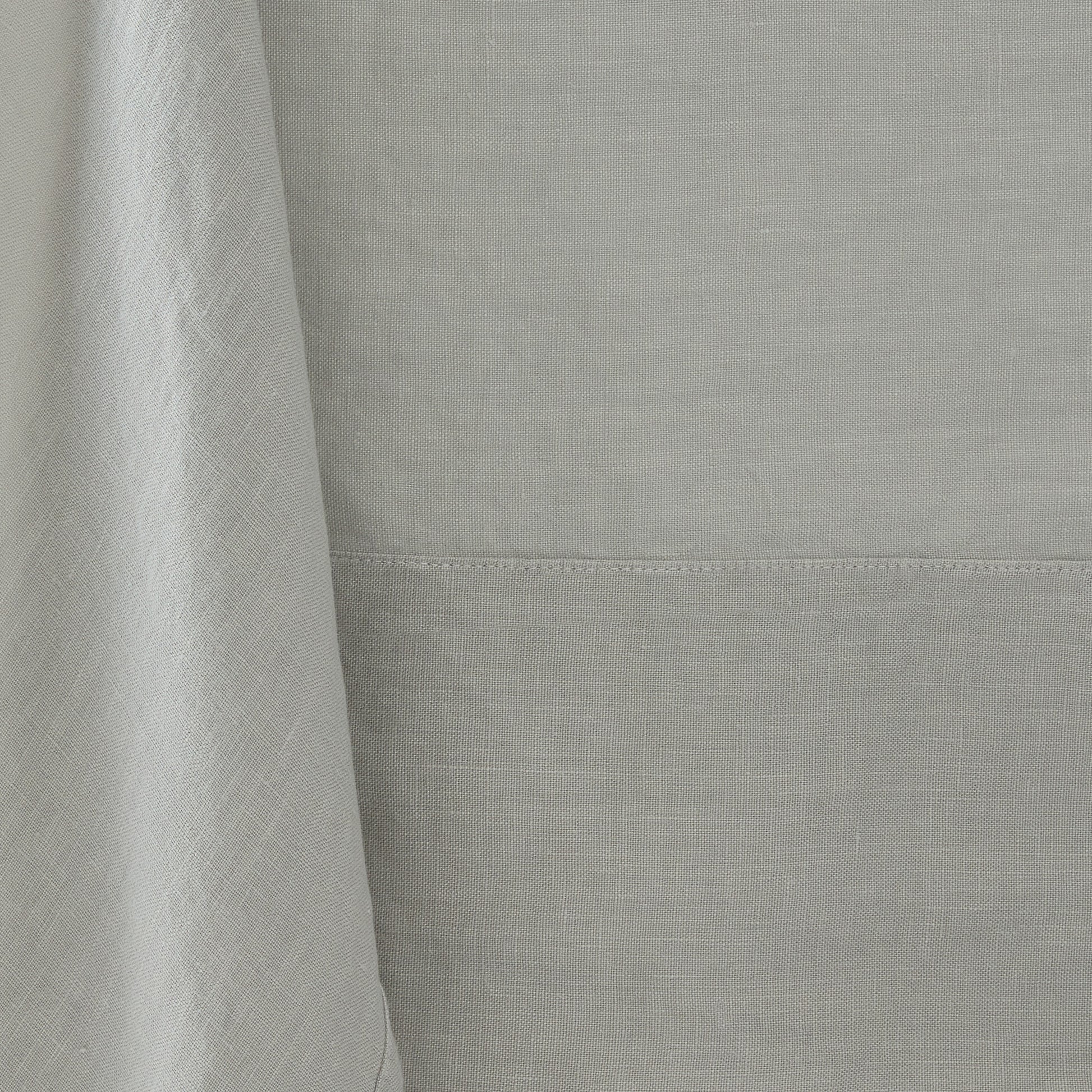 Hand-dyed grey linen tablecloth with visible fabric texture and a stitched border detail.