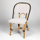 Rattan bistro chair with black frame, white, black, and red woven back and seat.
