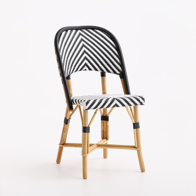 French bistro chair with black and white woven rattan chevron pattern and natural wooden frame on white background.