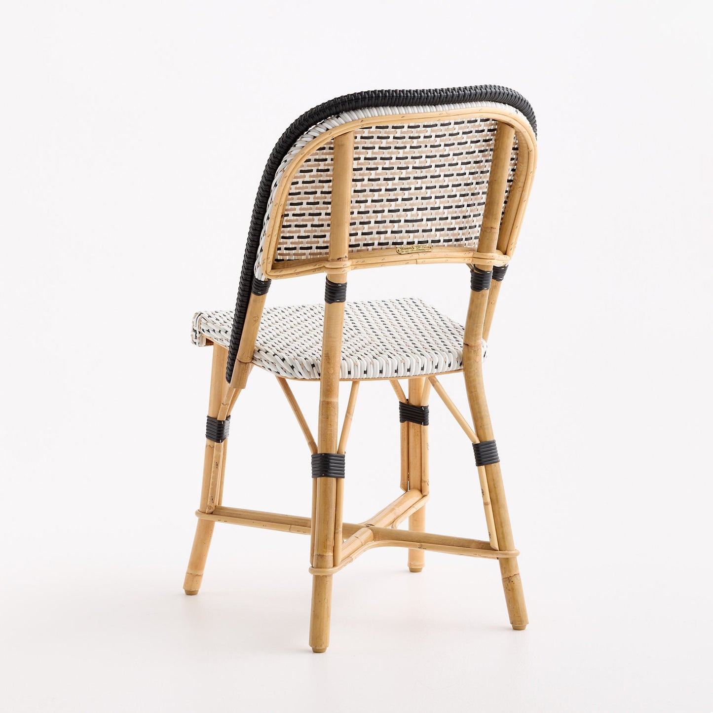 French bistro chair with woven black and white polka dot rattan seat and backrest on a natural wooden frame.