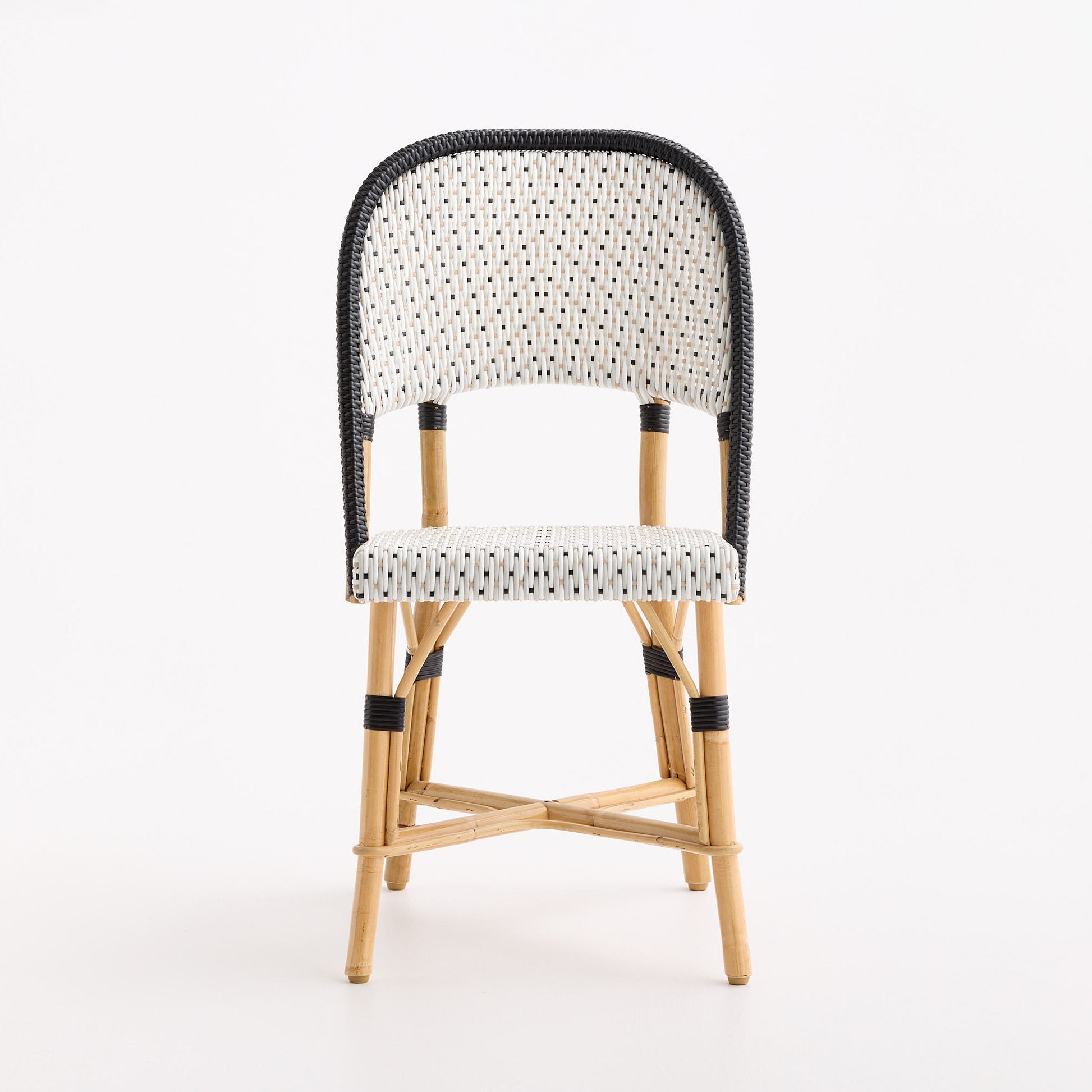 Maison Drucker French bistro chair with black and white polka dot woven rattan seat and back on a natural wooden frame.