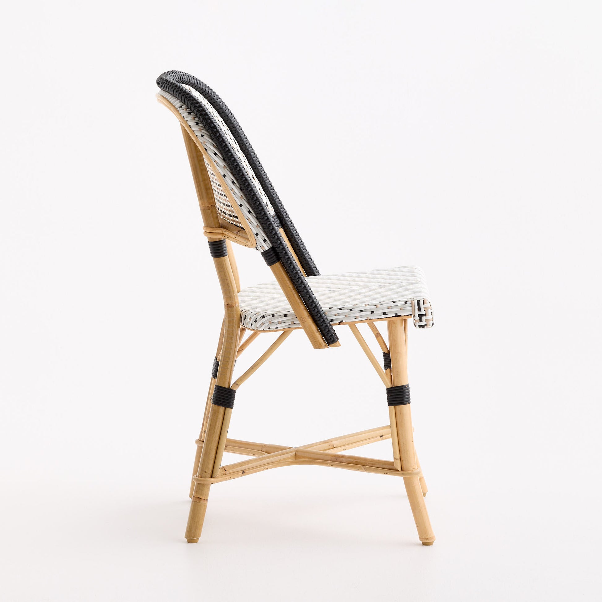 Maison Drucker French bistro chair with natural rattan frame and black and white polka dot woven seat and back.