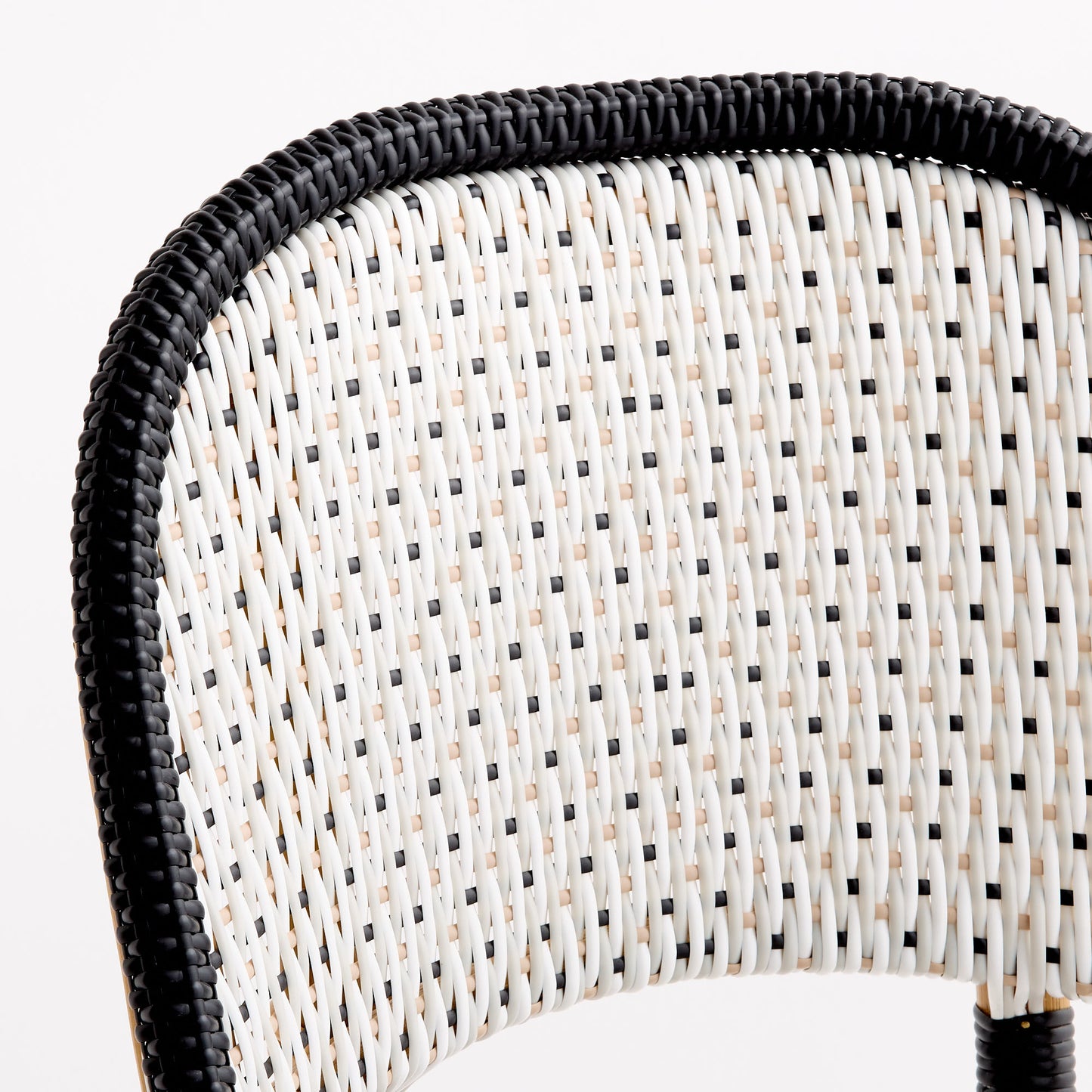 French bistro chair backrest with black and white woven rattan in a polka dot pattern and a solid black border.