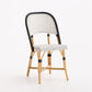 French bistro chair with black and white polka dot woven rattan seat and backrest on a natural wooden frame.