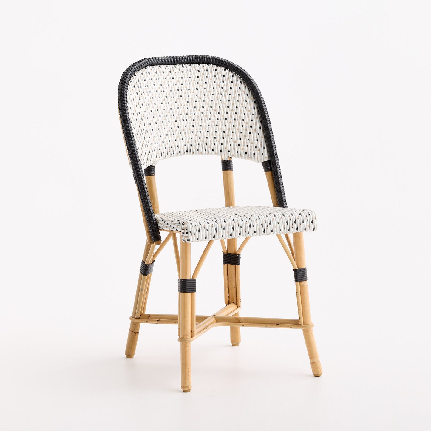 French bistro chair with black and white polka dot woven rattan seat and backrest on a natural wooden frame.