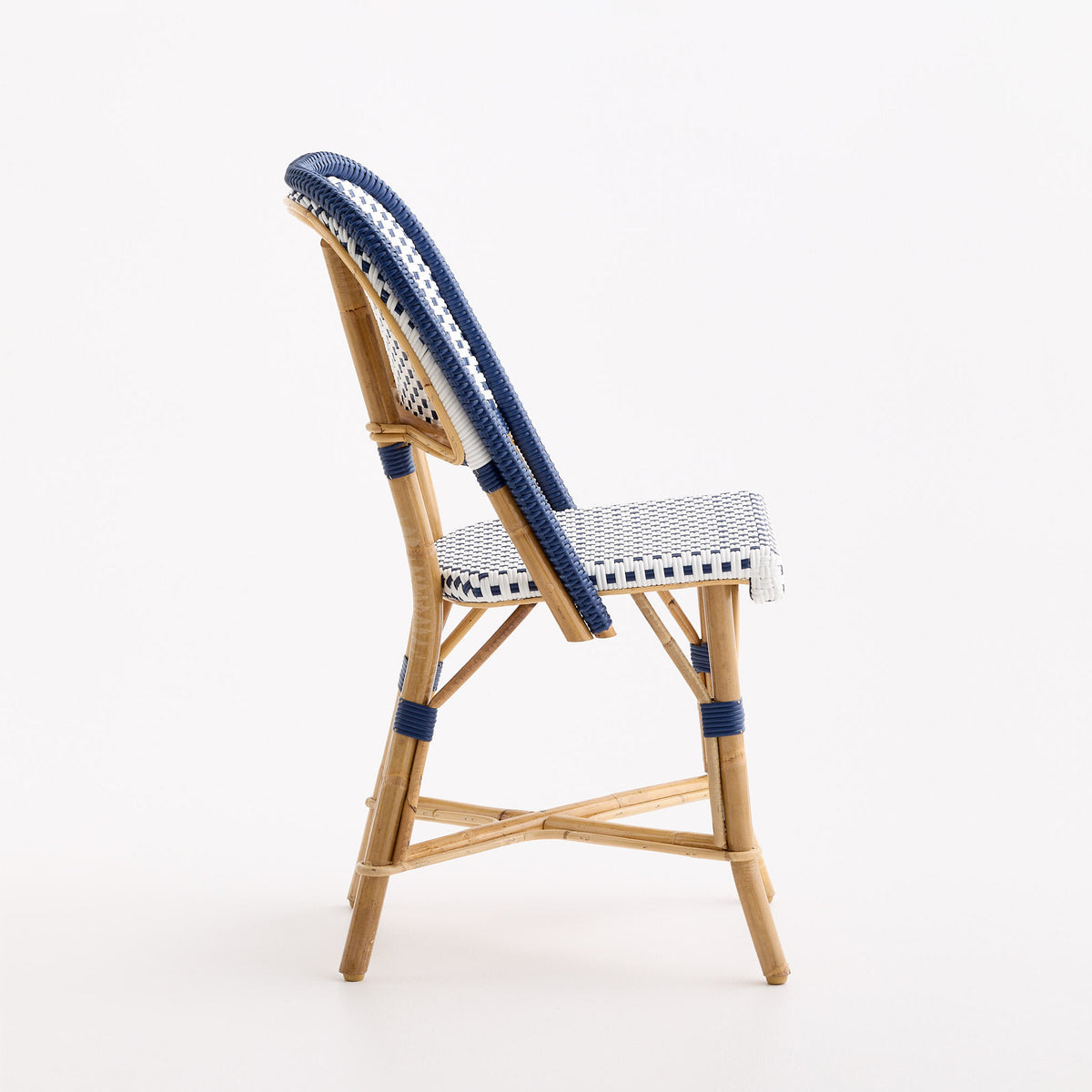 French bistro chair with blue and white polka dot woven rattan seat and back on a natural wooden frame.