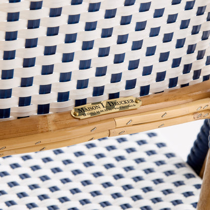 Maison Drucker rattan bistro chair with blue and white woven polka dot pattern and brass manufacturer nameplate.
