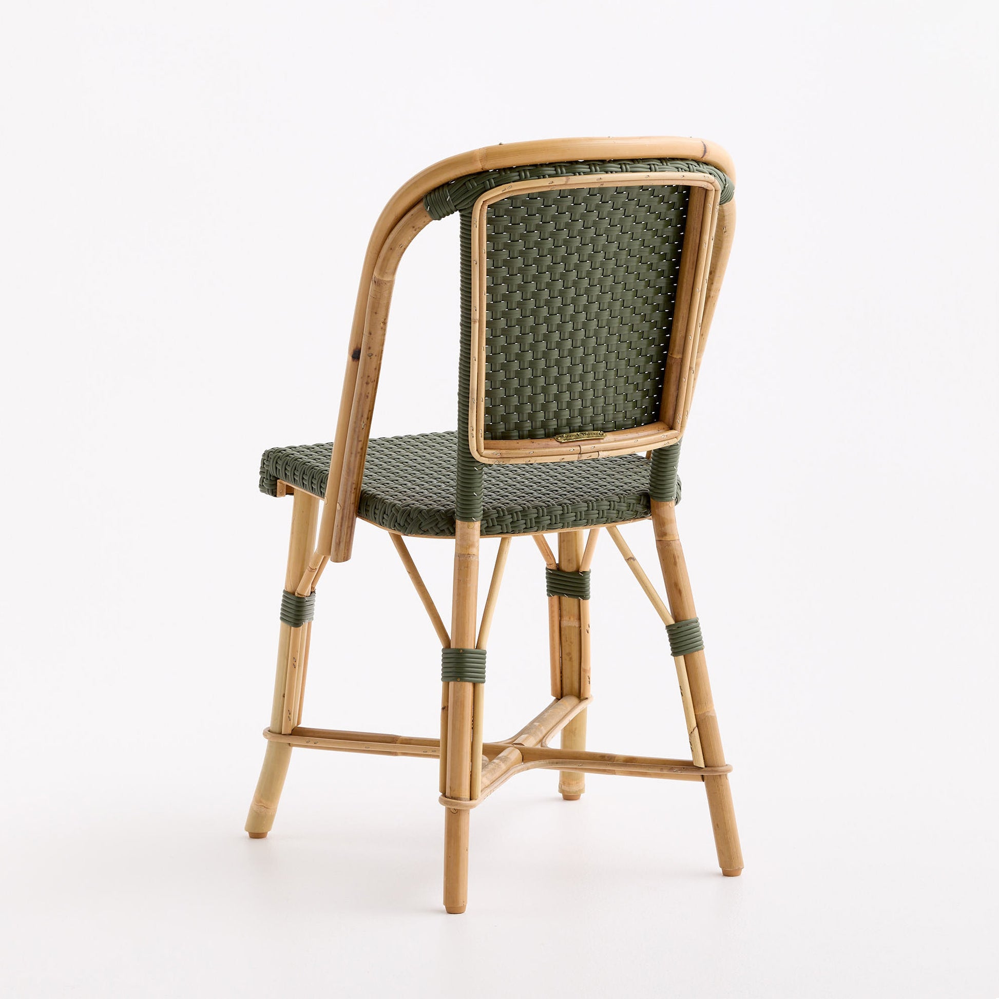 Olive green woven rattan bistro chair with a natural wooden frame in a classic French cafe style.