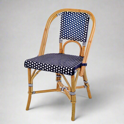 Rattan bistro chair with natural frame, navy blue and white spotted woven seat and back.
