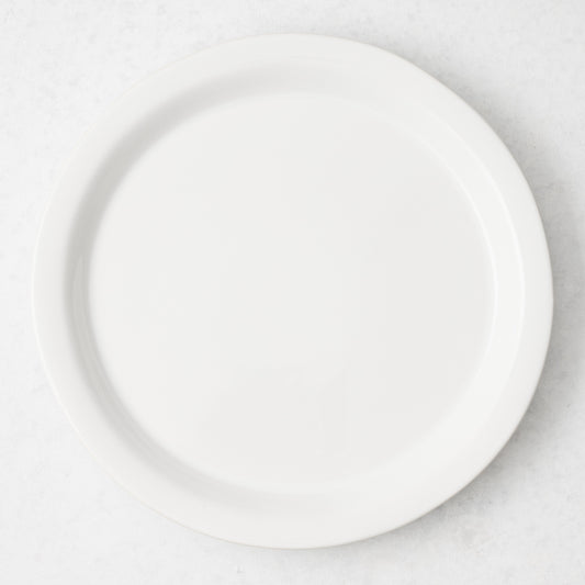 Ravello 11-inch white stoneware dinner plate with a sleek raised lip, viewed from directly above.