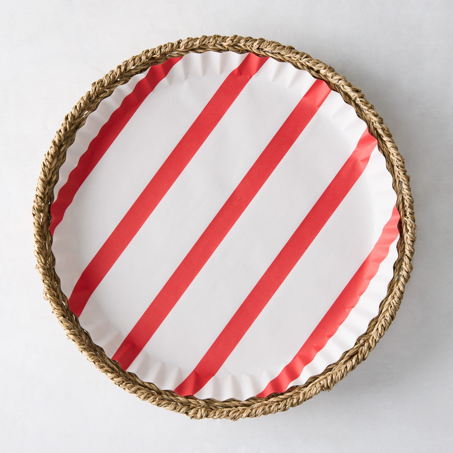 Round red striped parchment liner in a woven basket.