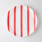 Round white parchment liner with vertical red stripes and ruffled edges.