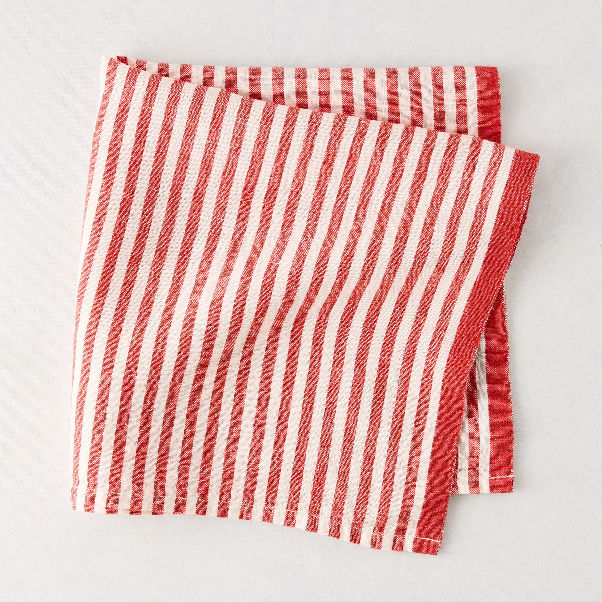 Red Ticking Stripe Linen Napkin, 21" square, with thin red and white stripes and a thicker red border.