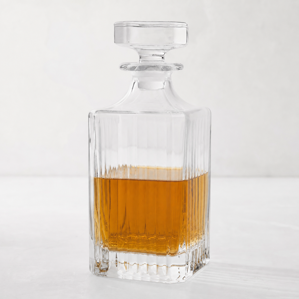 Regent Eco-Crystal Decanter, clear lead-free crystal, square with vertical fluting, partially filled with amber liquid.