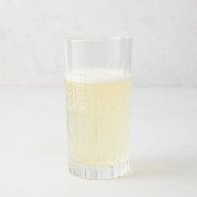 Regent Eco-Crystal High Ball Glass, clear, sleek, slender, with a bubbly light yellow drink.