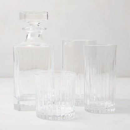 Regent Eco-Crystal Mixing Glass and matching decanter with two ribbed drinking glasses on a white surface.