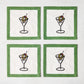 Set of four white linen coasters with green borders and embroidered martini glass illustrations with wreath garnishes.