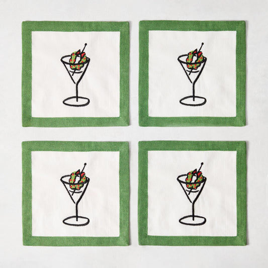 Set of four white linen coasters with green borders and embroidered martini glass illustrations with wreath garnishes.
