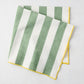 Rockport green and white stripe cotton napkin with yellow embroidered trim, folded.