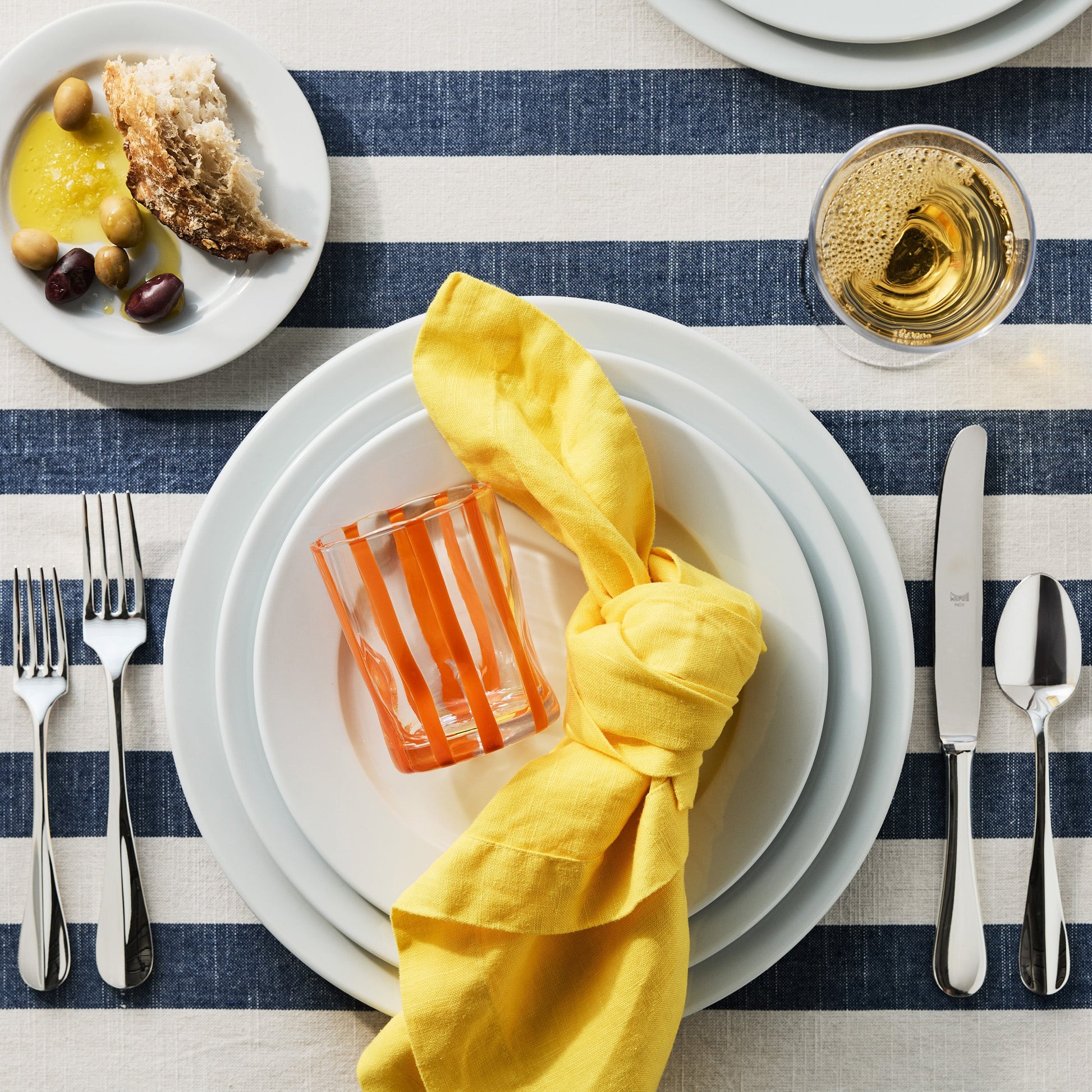 Roma Hotel silverplate 5-piece flatware set with elegant, polished finish on a striped table setting.