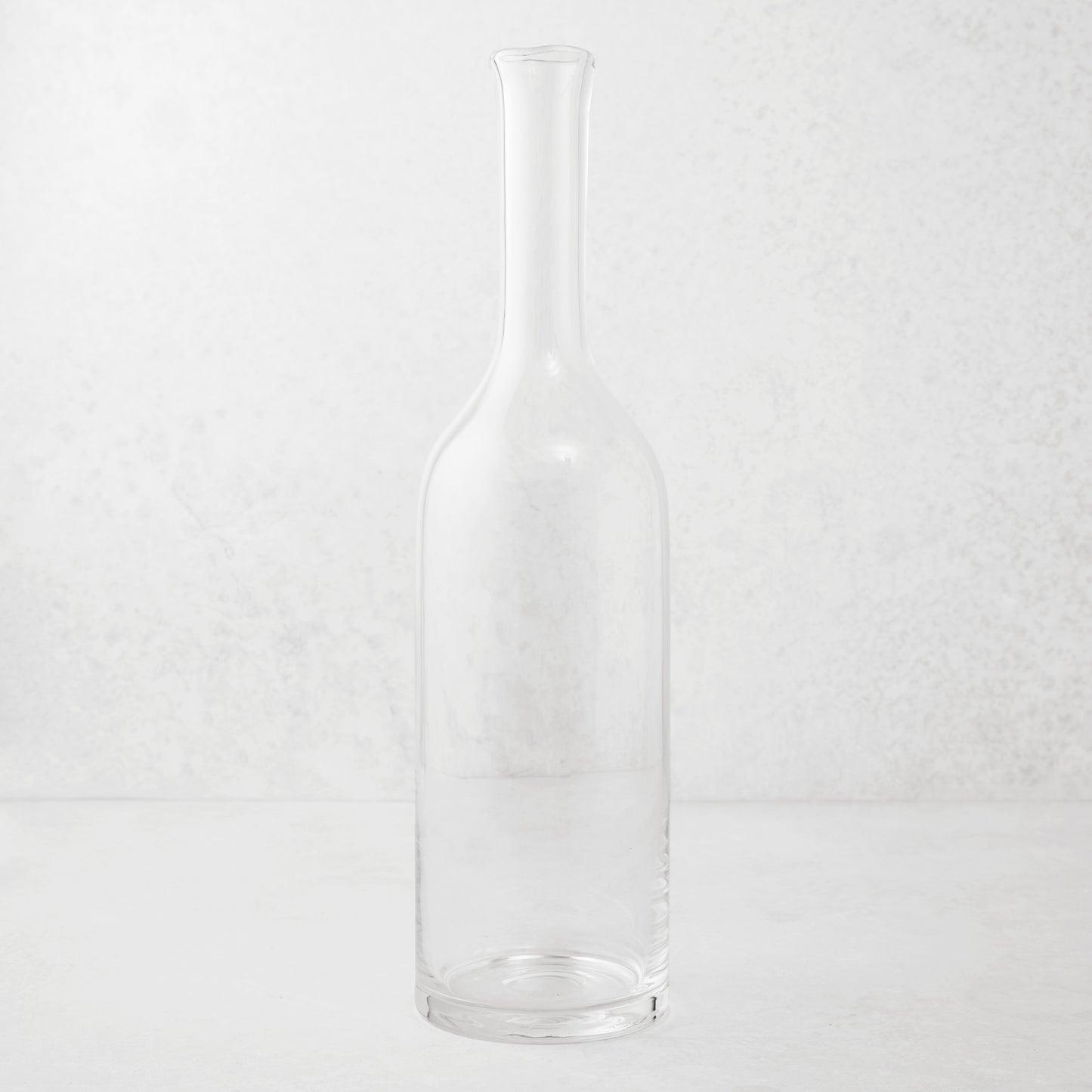 Clear mouth-blown glass Romeo wine carafe with a tall neck and scissor-cut rim.