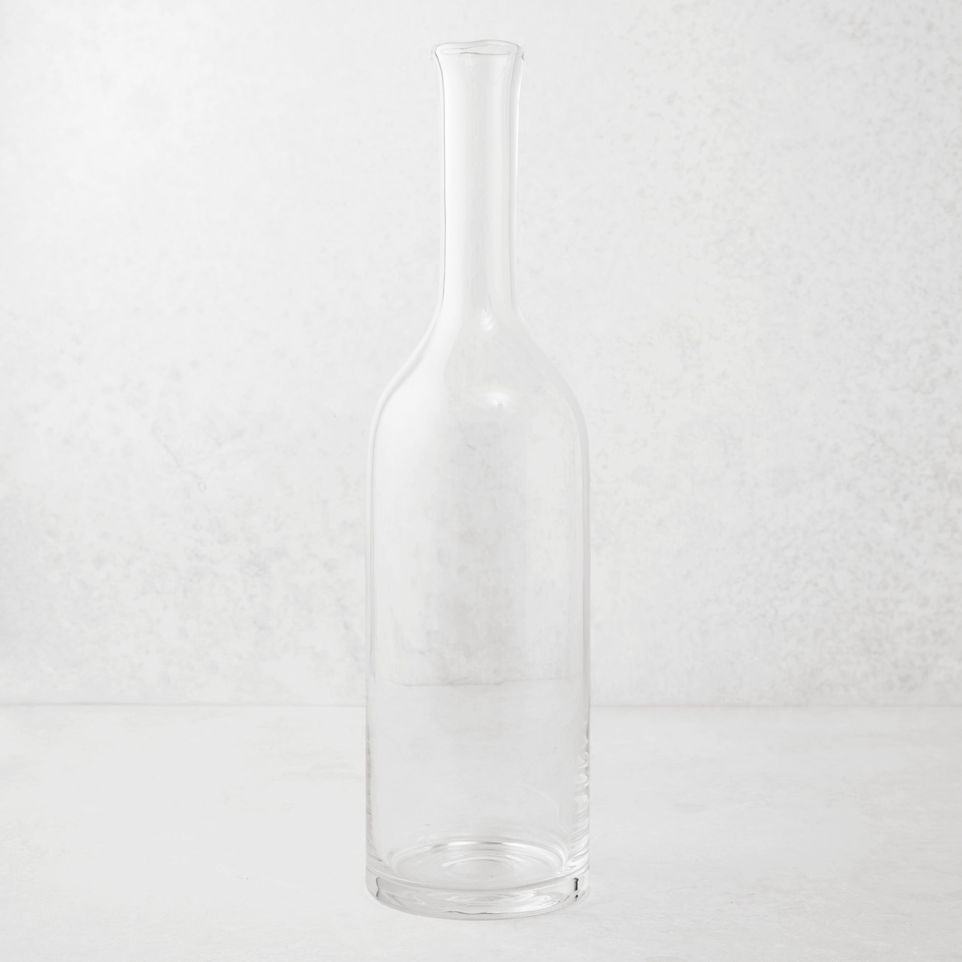 Clear mouth-blown glass Romeo wine carafe with a tall neck and scissor-cut rim.