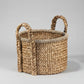 Round woven water hyacinth basket with braided handles.