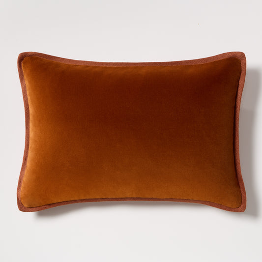 Rust orange velvet and linen lumbar pillow, 20x14 inches, with tonal trim.