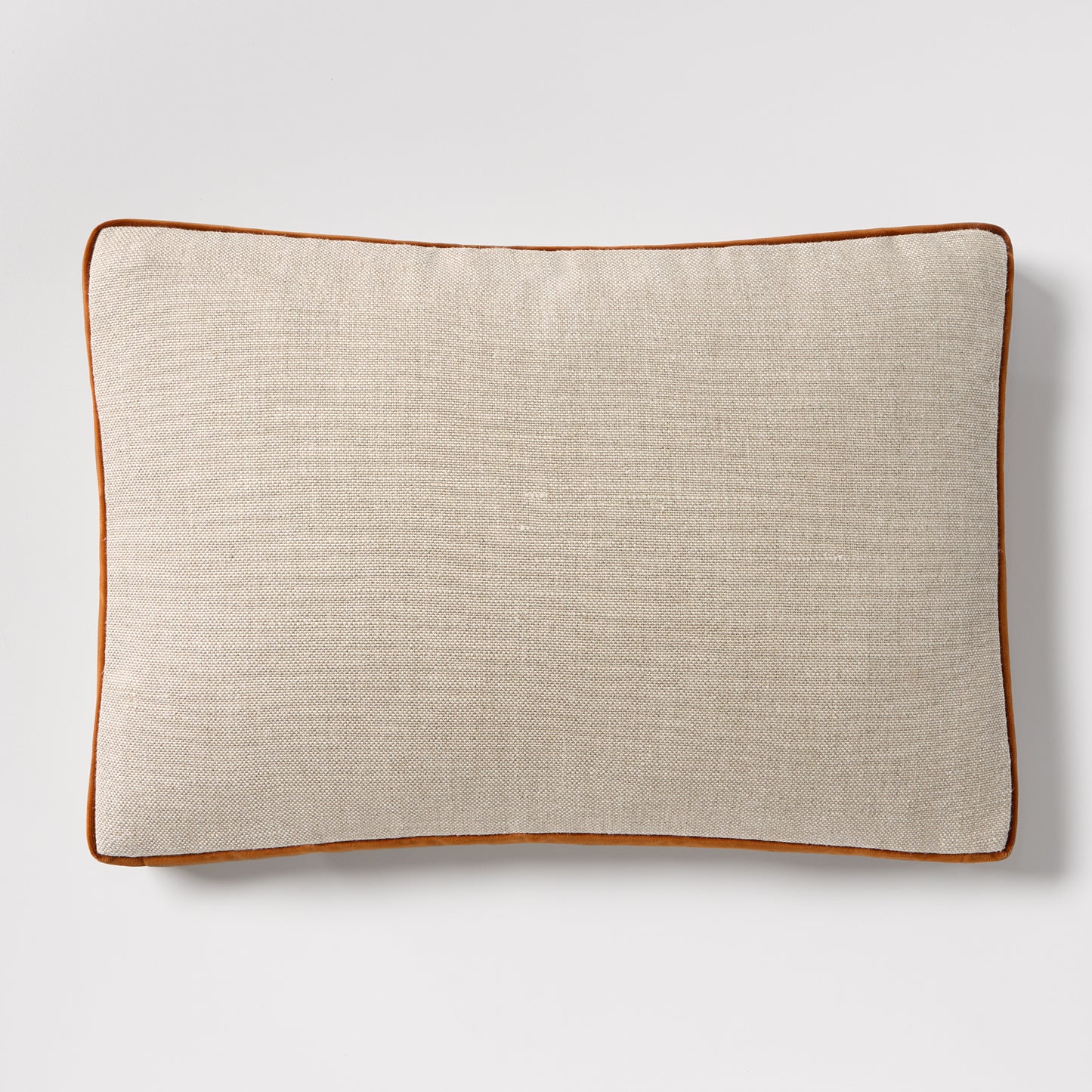 Linen lumbar pillow with rust orange velvet gusset and piping, 20"L x 14"H.