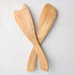 Hand-carved rustic spalted maple wood salad servers, light brown with unique grain, crossed on white.
