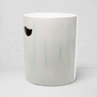 Rustic white ceramic cylinder garden stool with subtle blue streaks and a handle cutout.