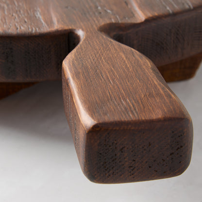Dark brown, hand-carved European pine wood serving board with a footed design and handle.