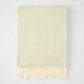 Sage Green Italian Herringbone Throw Blanket, cashmere-soft cotton-acrylic, with decorative fringe.