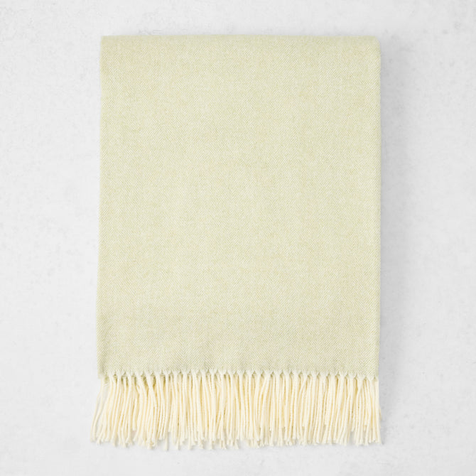 Sage Green Italian Herringbone Throw Blanket, cashmere-soft cotton-acrylic, with decorative fringe.
