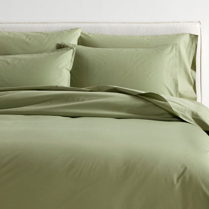 Sage green Italian percale duvet cover and two shams on a bed, showing soft, crisp cotton.