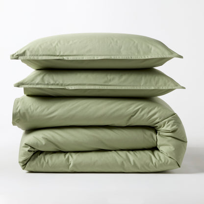 Sage green Italian percale duvet cover and two shams, folded and stacked.