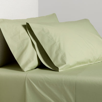 Sage green Italian percale sheet set with two pillowcases and flat sheet.