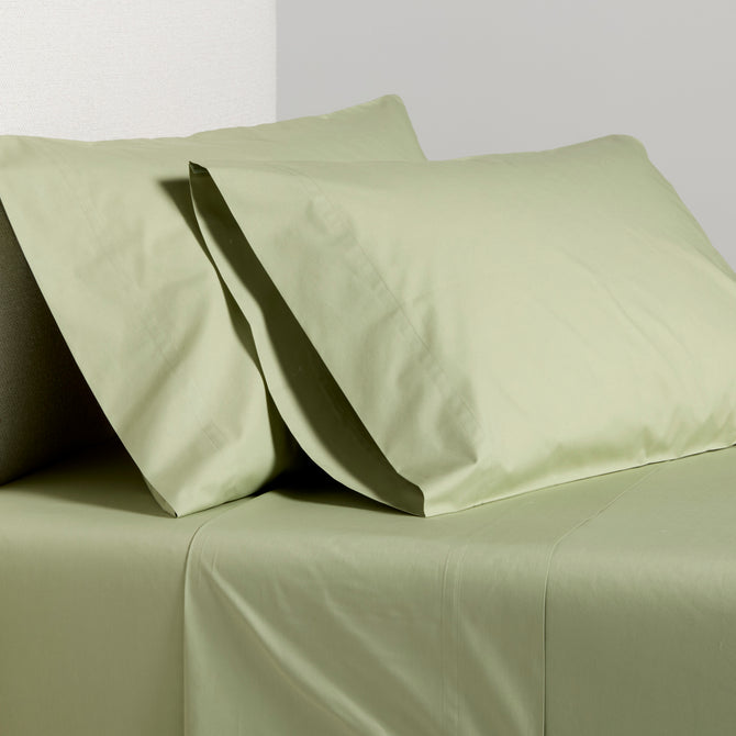 Sage green Italian percale sheet set with two pillowcases and flat sheet.