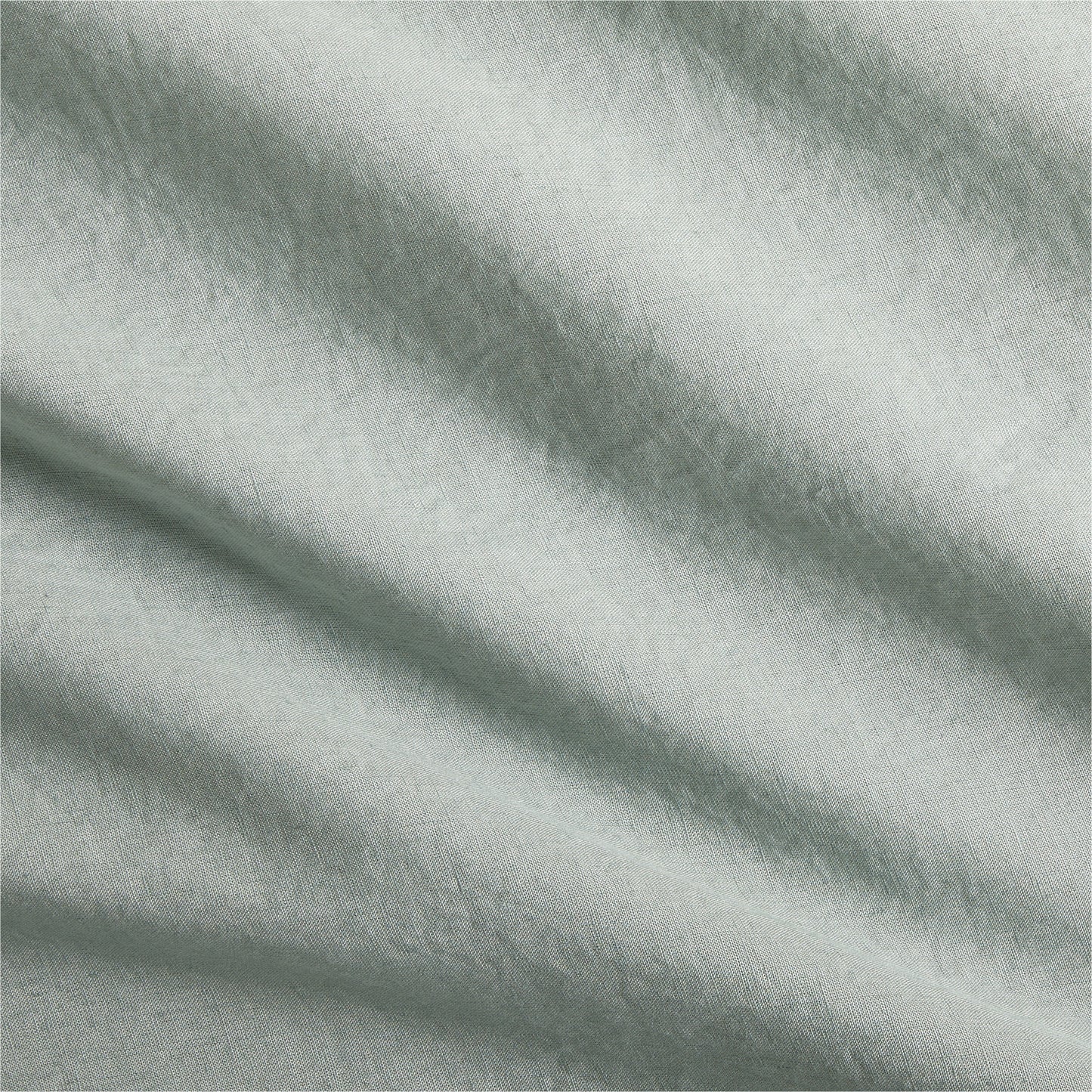 Sage green washed Italian linen duvet cover fabric with soft folds.